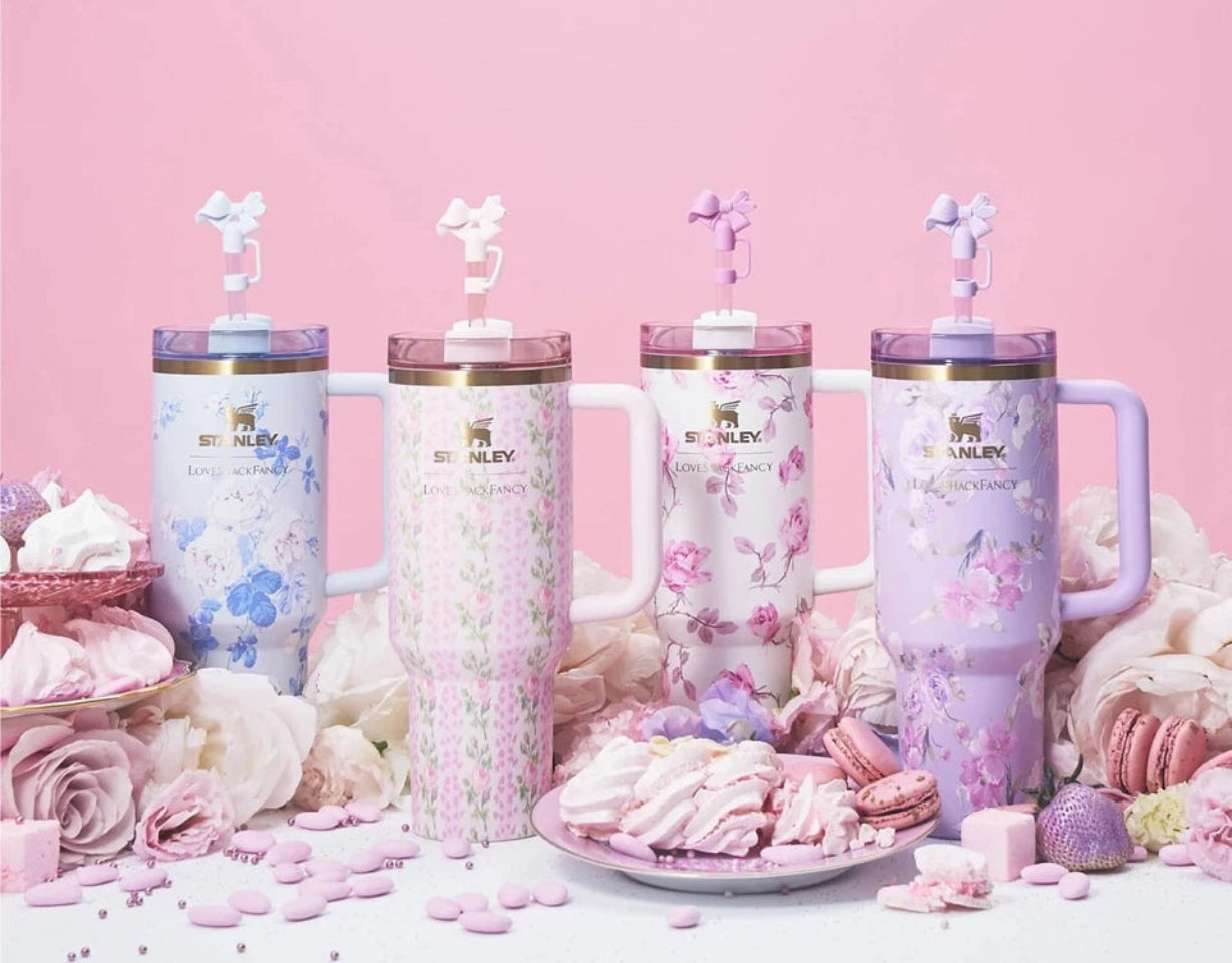 Set of four pink tumblers with floral designs on a pink background