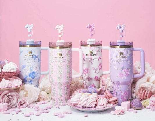 Set of four pink tumblers with floral designs on a pink background