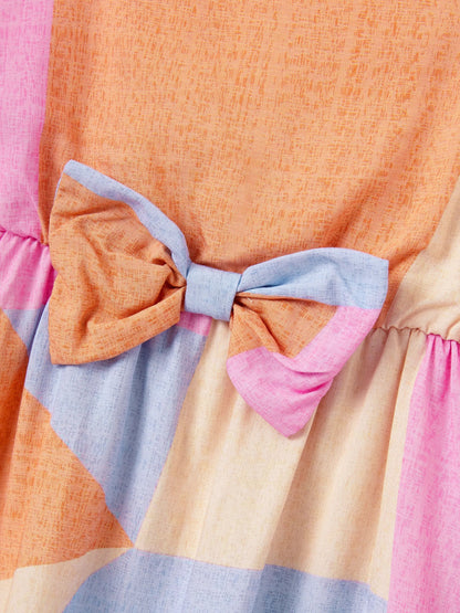 Colorful dress with a large bow detail on a multicolored background