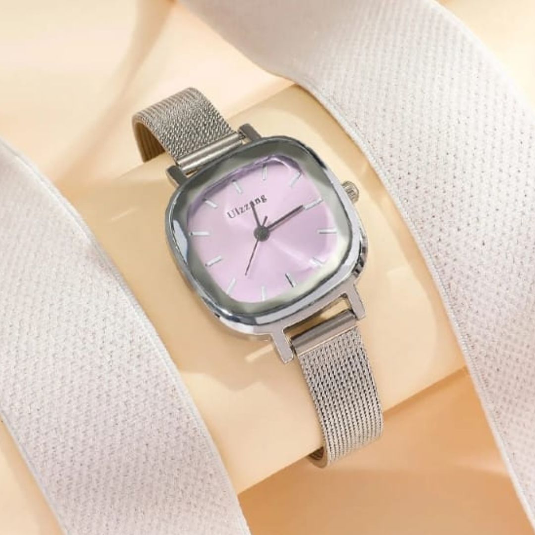 Silver watch with a pinkish-purple face on a light fabric background