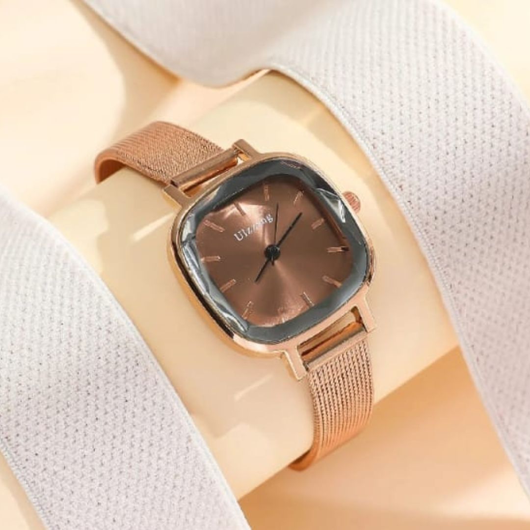 Rose gold watch with a brown face on a light fabric background